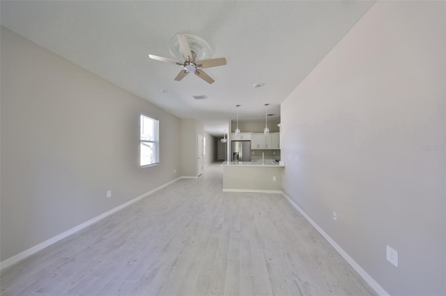 unfurnished living room featuring light wood-style flooring, baseboards, and a ceiling fan
