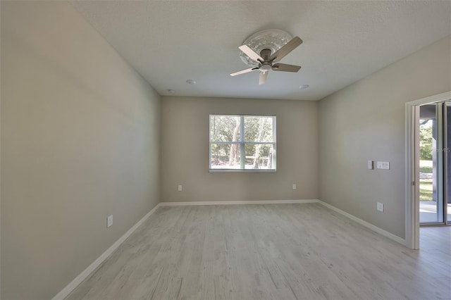 spare room with plenty of natural light, ceiling fan, light wood-type flooring, and baseboards