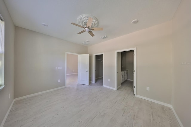 unfurnished bedroom featuring ceiling fan, visible vents, baseboards, and light wood-style flooring