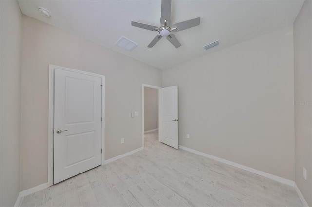 unfurnished bedroom featuring a ceiling fan, light wood-style floors, visible vents, and baseboards