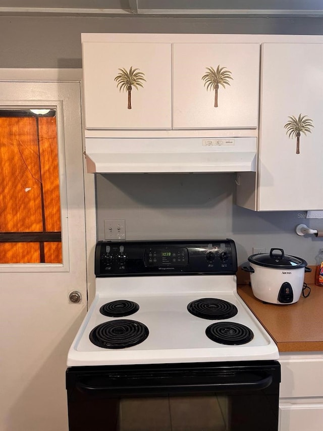 5562 S US-301, Bushnell, FL 33513 - kitchen featuring under cabinet range hood, electric range, and white cabinetry