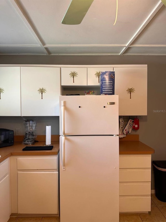 5562 S US-301, Bushnell, FL 33513 - kitchen with light tile patterned flooring, white cabinets, freestanding refrigerator, and black microwave