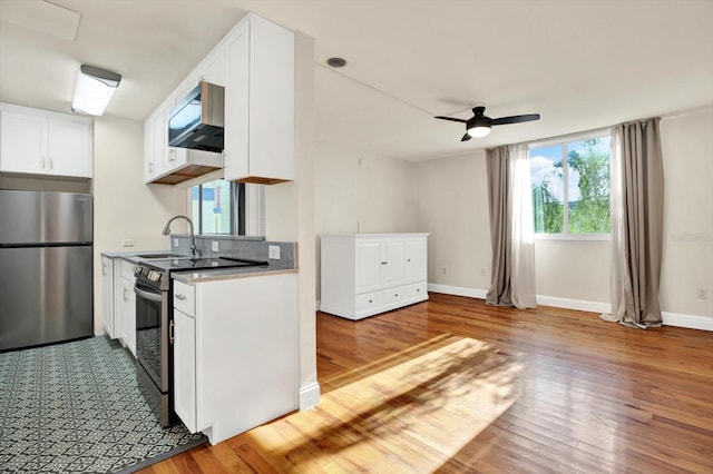 1301 S Howard Ave Unit B24, Tampa, FL 33606 - kitchen with white cabinetry, appliances with stainless steel finishes, a sink, and light wood finished floors