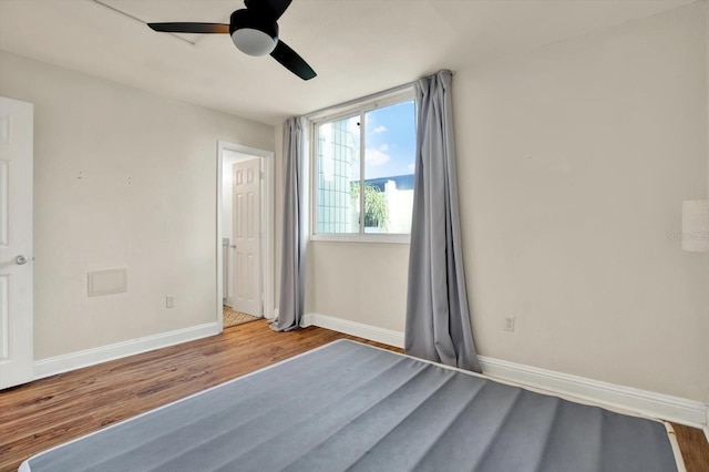 1301 S Howard Ave Unit B24, Tampa, FL 33606 - unfurnished bedroom with wood finished floors, baseboards, and ceiling fan