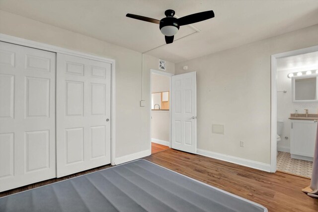 1301 S Howard Ave Unit B24, Tampa, FL 33606 - unfurnished bedroom featuring ensuite bathroom, baseboards, a ceiling fan, wood finished floors, and a closet