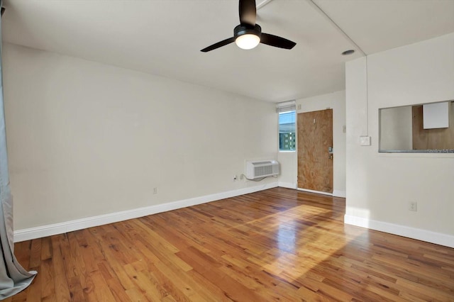 1301 S Howard Ave Unit B24, Tampa, FL 33606 - unfurnished living room with baseboards, a ceiling fan, wood finished floors, and an AC wall unit