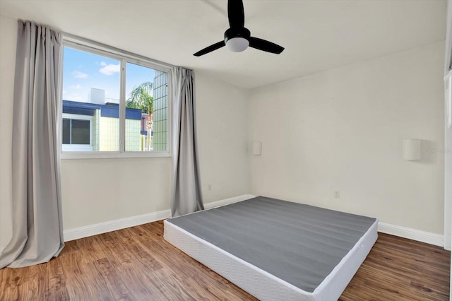 1301 S Howard Ave Unit B24, Tampa, FL 33606 - unfurnished bedroom with wood finished floors, a ceiling fan, and baseboards