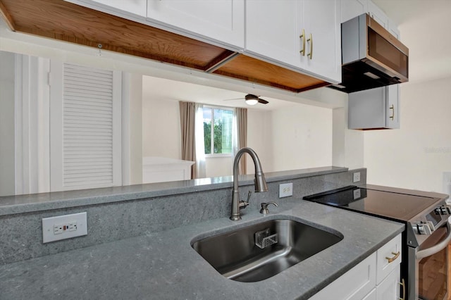 1301 S Howard Ave Unit B24, Tampa, FL 33606 - kitchen featuring dark stone countertops, a sink, extractor fan, stainless steel electric range oven, and white cabinetry