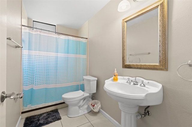bathroom with tile patterned floors, a shower with curtain, baseboards, and toilet