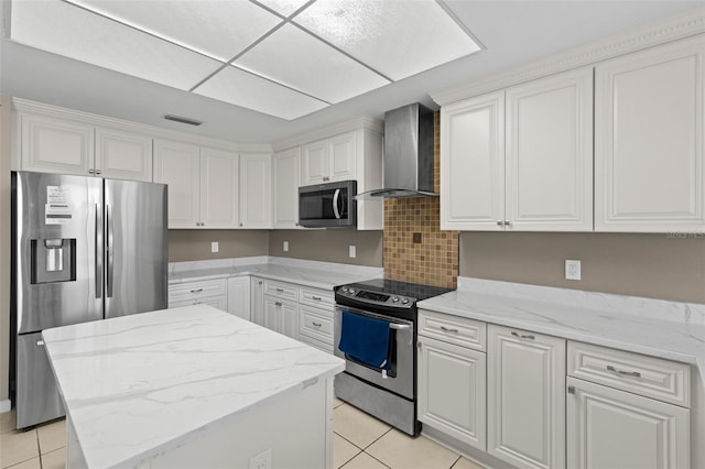 kitchen featuring white cabinetry, wall chimney exhaust hood, light tile patterned flooring, and stainless steel appliances