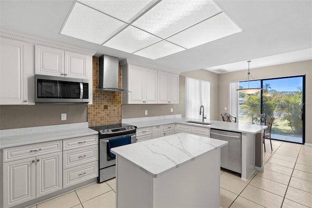 kitchen with a peninsula, light tile patterned flooring, stainless steel appliances, wall chimney exhaust hood, and a sink