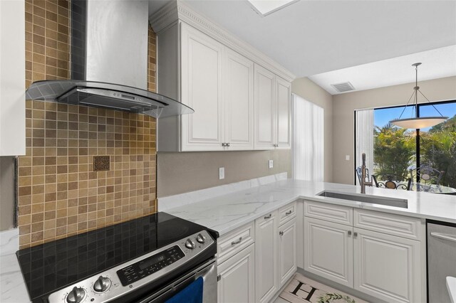 kitchen with visible vents, wall chimney range hood, appliances with stainless steel finishes, white cabinetry, and a sink
