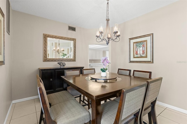 dining area featuring light tile patterned flooring, a notable chandelier, baseboards, and visible vents