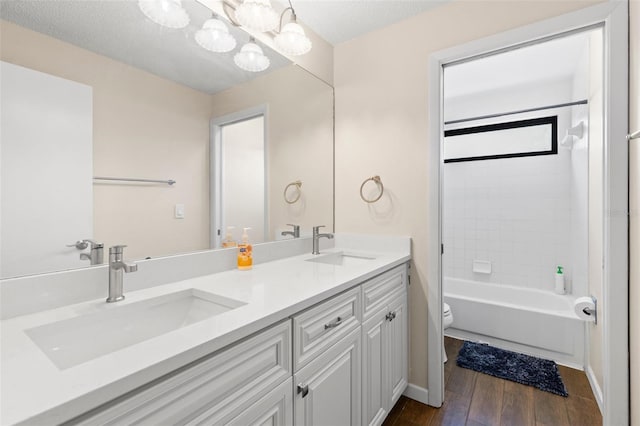 bathroom featuring double vanity, toilet, wood-type flooring, and a sink