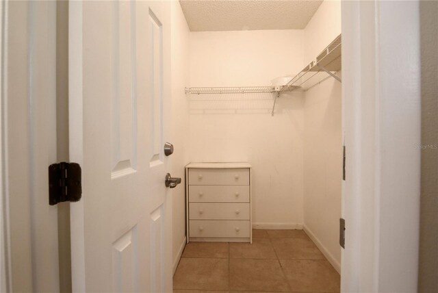 walk in closet with light tile patterned flooring