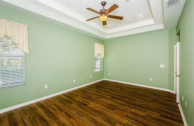 15925 Pond Rush Ct, Land O Lakes, FL 34638 - empty room featuring dark wood-type flooring, a raised ceiling, a ceiling fan, and recessed lighting