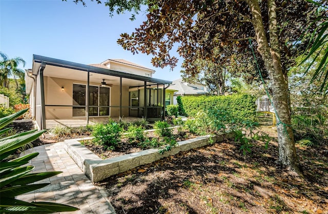 15925 Pond Rush Ct, Land O Lakes, FL 34638 - back of property with a sunroom, a ceiling fan, stucco siding, and a patio area