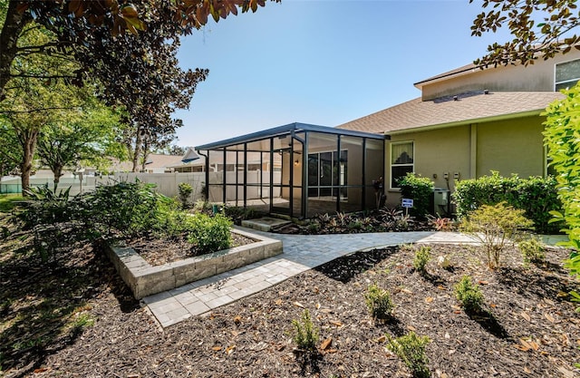 15925 Pond Rush Ct, Land O Lakes, FL 34638 - rear view of property with stucco siding, a sunroom, and a patio
