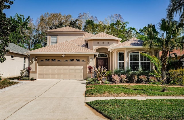 15925 Pond Rush Ct, Land O Lakes, FL 34638 - mediterranean / spanish home featuring stucco siding, a garage, and driveway