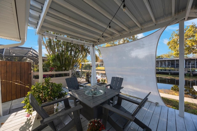 deck with a water view and outdoor dining area