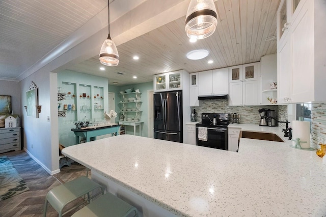 kitchen featuring a peninsula, a sink, open shelves, light stone countertops, and black appliances