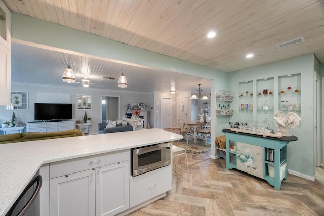 kitchen with visible vents, open floor plan, white cabinetry, and stainless steel microwave