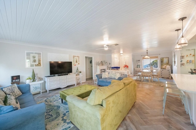 living area featuring ornamental molding and ceiling fan
