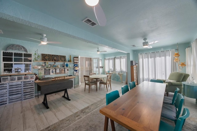 interior space featuring a ceiling fan, wood finished floors, and visible vents