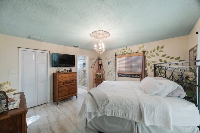 bedroom featuring a closet, a chandelier, visible vents, and a textured ceiling