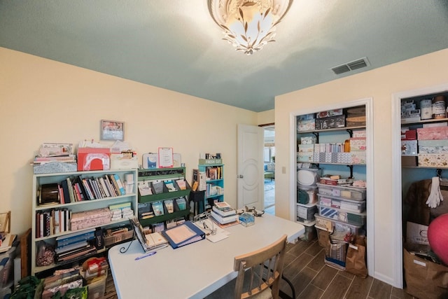 office space with a chandelier, wood tiled floor, and visible vents