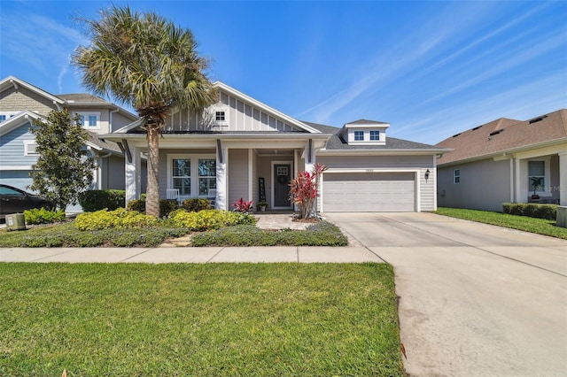view of front facade with a front yard, an attached garage, board and batten siding, and driveway