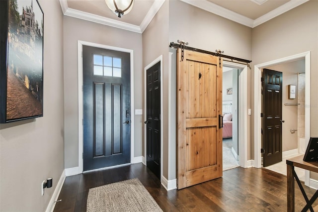 foyer featuring a barn door, baseboards, dark wood-style floors, and ornamental molding