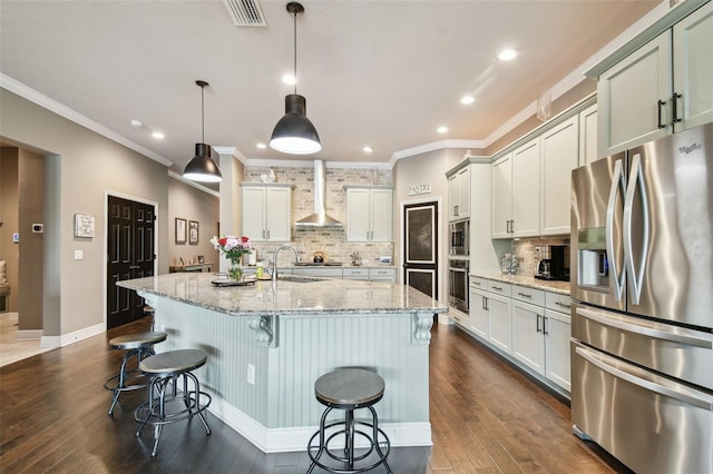 kitchen with backsplash, appliances with stainless steel finishes, dark wood-style flooring, and wall chimney range hood