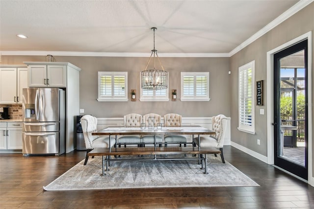 dining space featuring dark wood finished floors, an inviting chandelier, baseboards, and ornamental molding