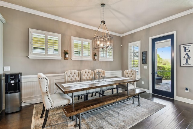 dining area with an inviting chandelier, baseboards, dark wood-style flooring, and ornamental molding