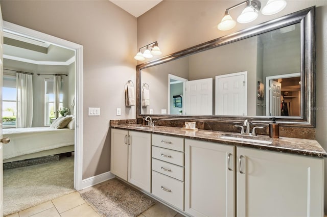 ensuite bathroom with tile patterned flooring, double vanity, ensuite bathroom, and a sink