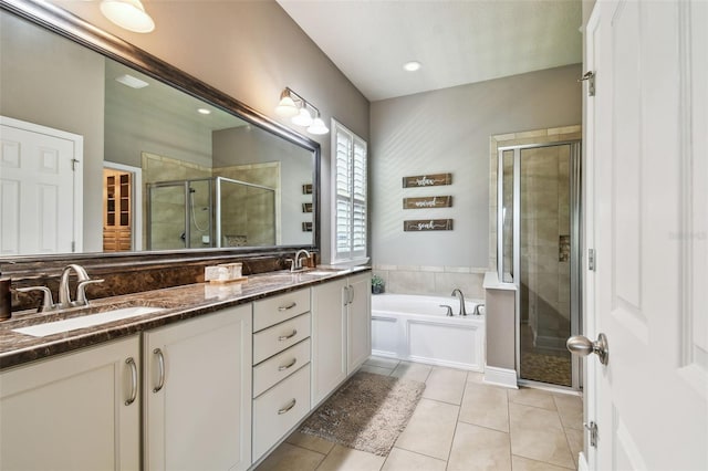 bathroom featuring a garden tub, a stall shower, a sink, tile patterned flooring, and double vanity