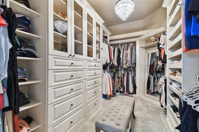 walk in closet featuring a notable chandelier and carpet