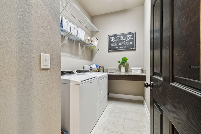 laundry room featuring light tile patterned floors, laundry area, independent washer and dryer, and baseboards