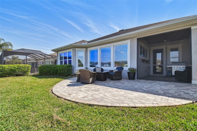 rear view of house featuring stucco siding, a patio, and a yard