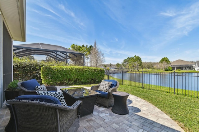 view of patio / terrace featuring a lanai, fence, and a water view