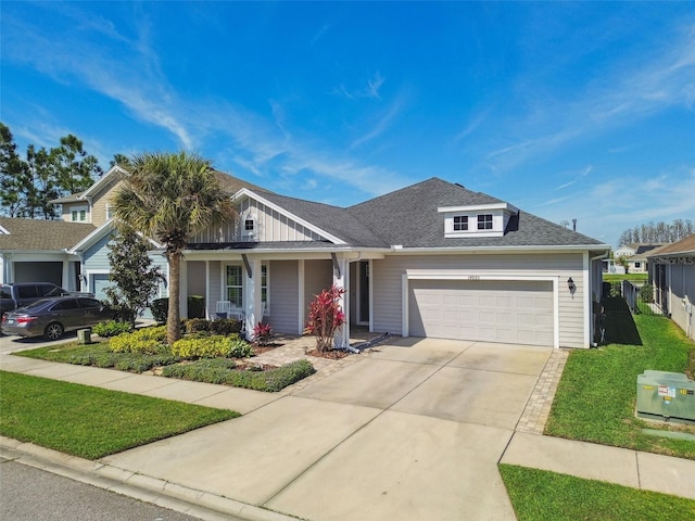 view of front of property featuring fence, driveway, an attached garage, a shingled roof, and a front lawn
