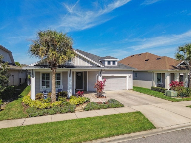 view of front of house featuring a porch, a front yard, a garage, and driveway