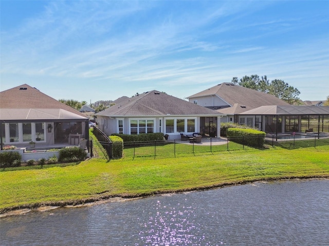 view of front of home featuring a patio area, a front yard, a fenced backyard, and a water view