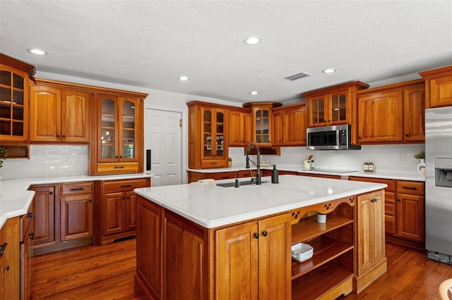 20315 Mid Ct, Lutz, FL 33558 - kitchen featuring a sink, appliances with stainless steel finishes, a kitchen island with sink, and light countertops