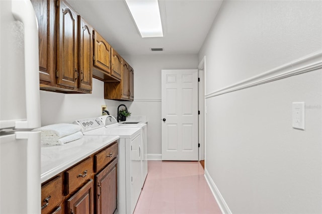 20315 Mid Ct, Lutz, FL 33558 - washroom featuring visible vents, washing machine and dryer, cabinet space, baseboards, and light tile patterned flooring