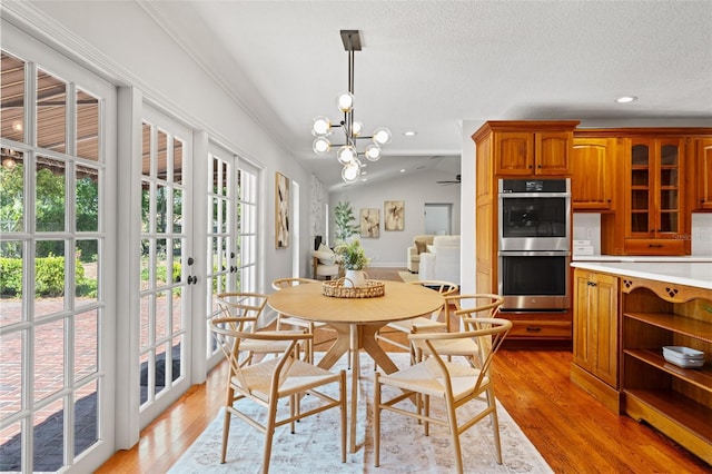 20315 Mid Ct, Lutz, FL 33558 - dining space with lofted ceiling, recessed lighting, a textured ceiling, a chandelier, and light wood-style flooring