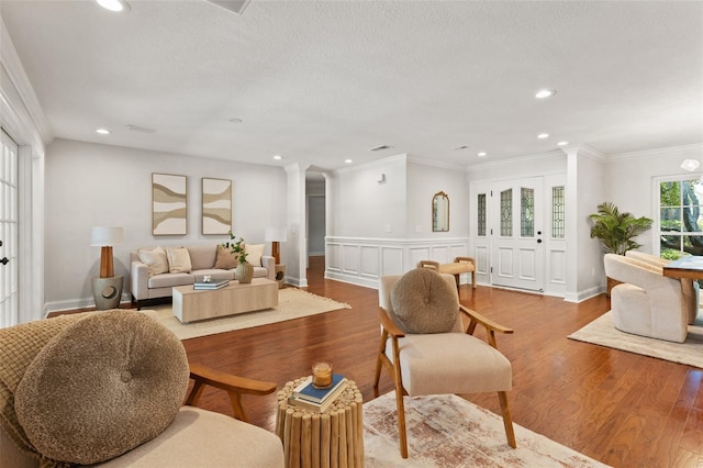 20315 Mid Ct, Lutz, FL 33558 - living room featuring a textured ceiling, recessed lighting, wood finished floors, ornate columns, and ornamental molding