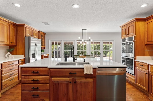 20315 Mid Ct, Lutz, FL 33558 - kitchen featuring appliances with stainless steel finishes, a sink, light countertops, french doors, and wood finished floors