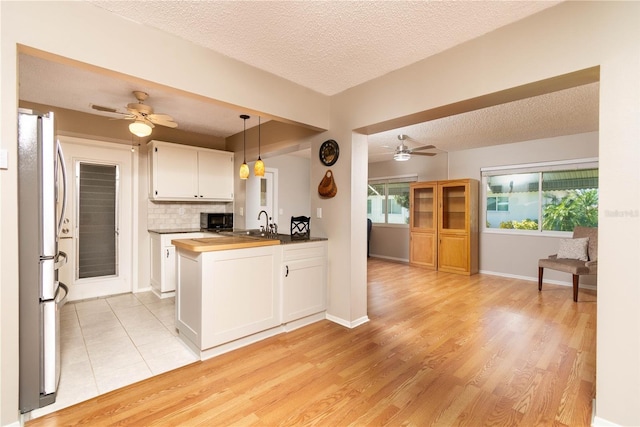 9870 36th Way N, Pinellas Park, FL 33782 - kitchen featuring freestanding refrigerator, black microwave, a ceiling fan, a textured ceiling, and white cabinets